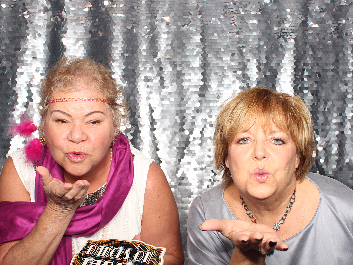 Photo Magic Events' founder Deb Newman and friend posing in a photo booth rental