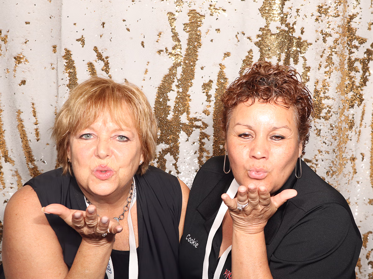 Founder of Photo Magic Events, Deb Newman and a friend using a photo booth rental